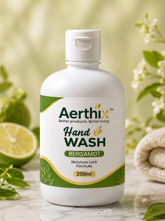 A 200ml bottle of Aerthix Hand Wash in Bergamot scent, displayed on a marble surface with a green and white background featuring fresh bergamot, mint leaves, and a rolled towel.